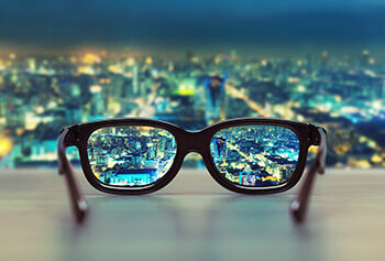 Looking through a pair of glasses overlooking a city